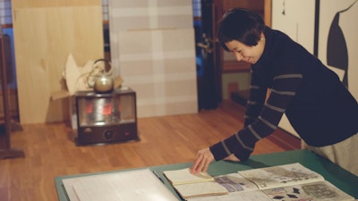 Karakami Printmaking Artist Overlooking Her Sketch Book. Learn from this artist how to create custom decorative paper. #creativevacation #vawaa #japan #printmaking #printmakingtechniques #decorativepaper #papercrafts #homedecor #slowtravel  #howtomake #interiordesign