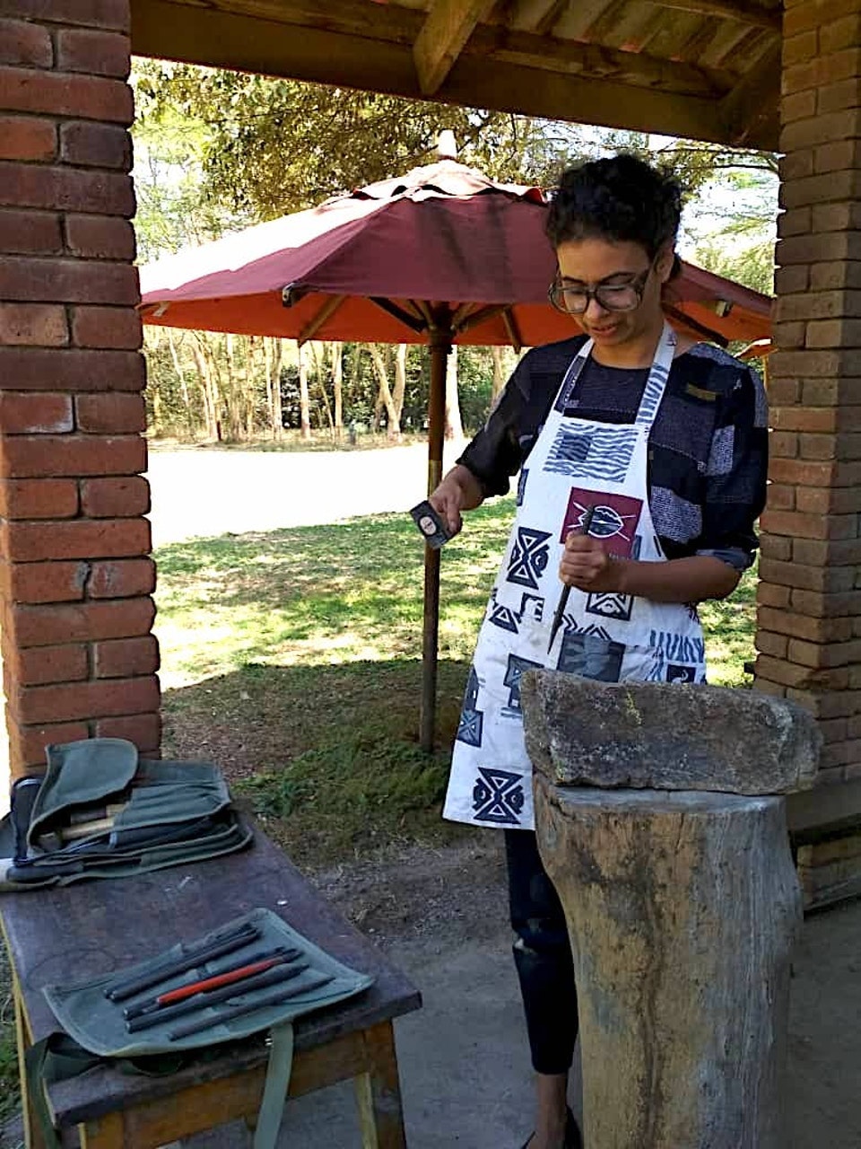 Sculpting a serpentine stone in Mieke's studio. Courtesy of Sarika.