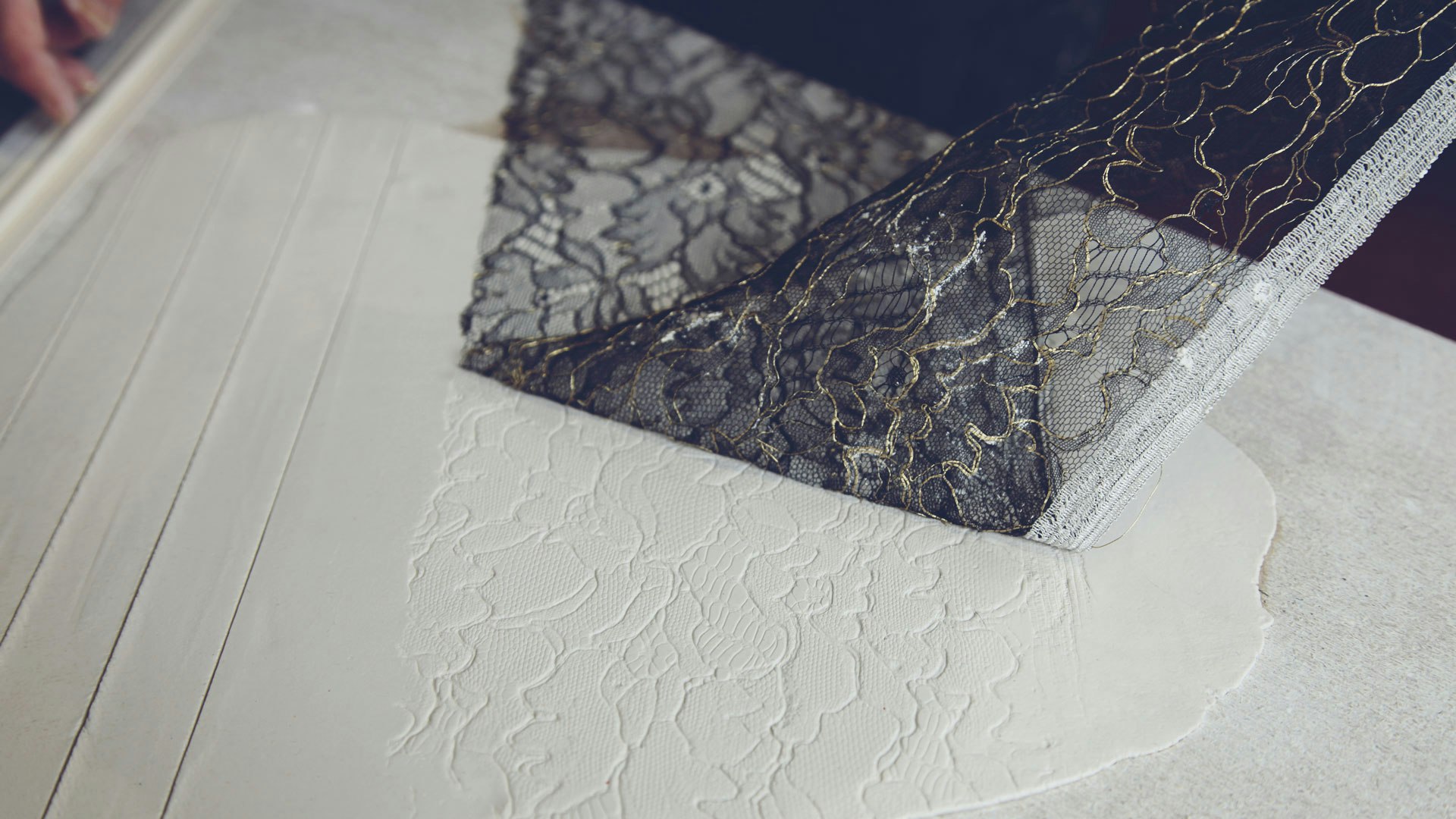 Experimenting with a piece of fabric to add texture and decorate this piece.