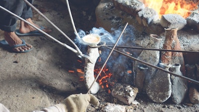 Taking the mold out of the low fire using steel tongs 