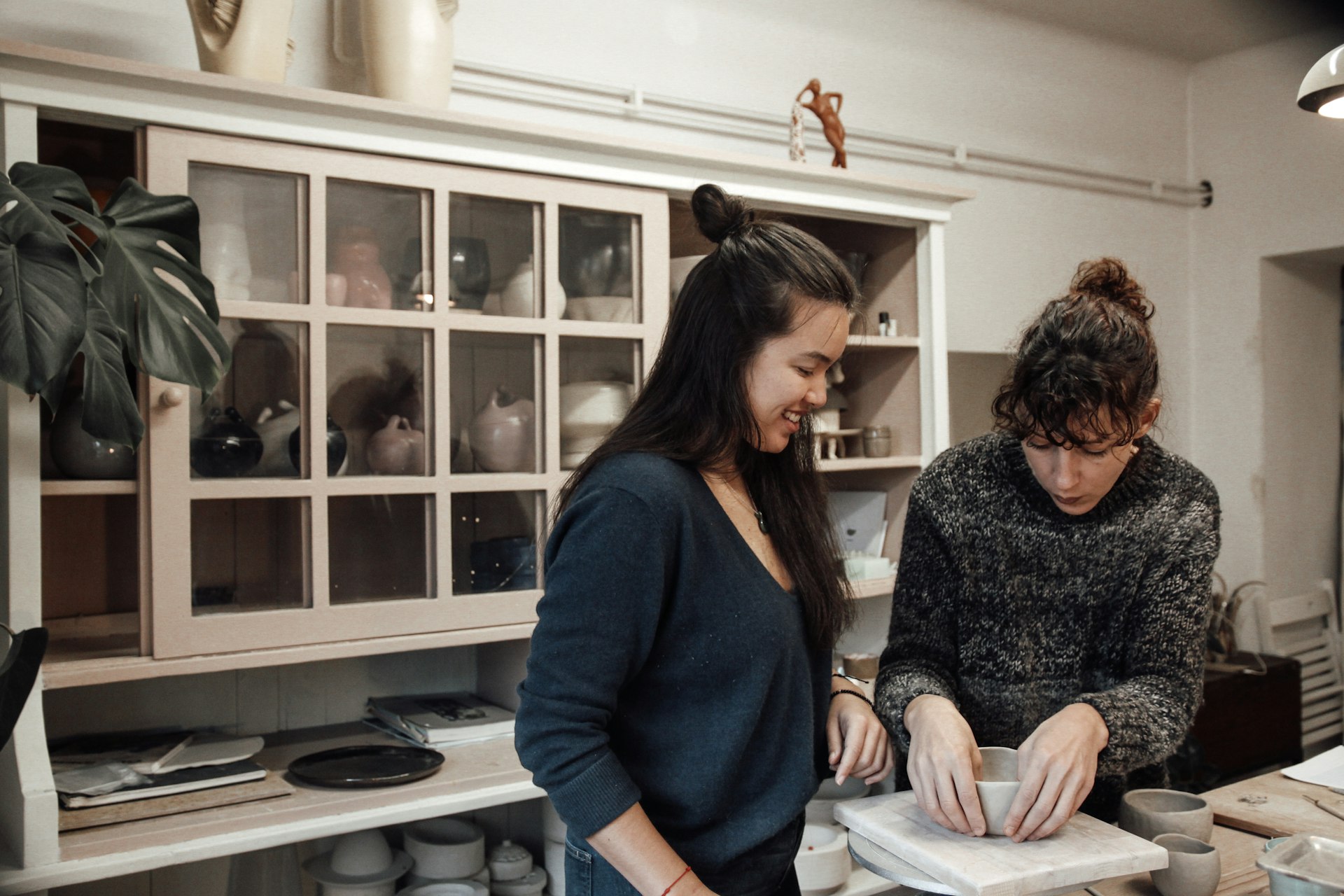 Artist and guest learning ceramics in the artist studio