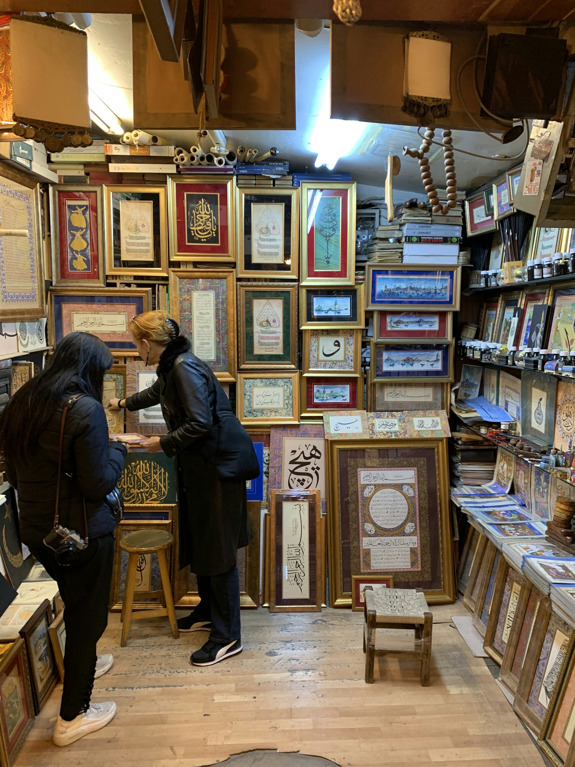 two women in a shop filled with paintings in turkey